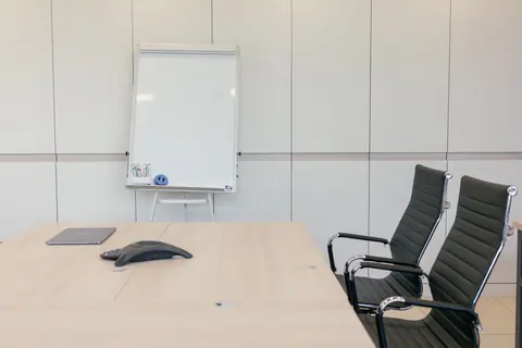 Sauberer Besprechungsraum mit Konferenztisch und Whiteboard